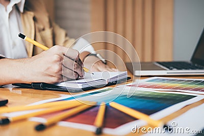 Creative graphic designer using graphics tablet to choosing color swatch samples chart for selection coloring with work tools and Stock Photo