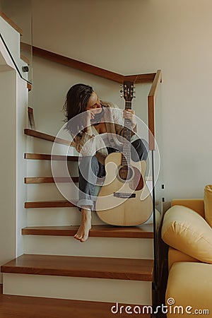 Creative hobby. Talented young female musician sit in armchair alone compose instrumental song using classic guitar. Copy space Stock Photo