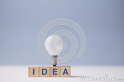 Creative idea generation. Creativity and innovation. Originative thinking. Wooden cubes, idea inscription and lightbulb Stock Photo