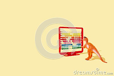 Creative idea made of red abacus and dinosaur on bright yellow backgrpund. Minimal back to school template concept Stock Photo