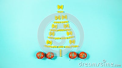 The creative installation show Christmas tree made of pasta. Tomatoes mean red gift boxes decorated with green string Stock Photo