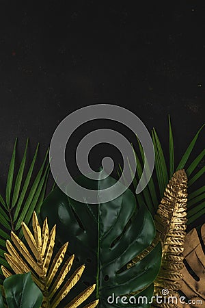 Creative layout with gold and green tropical palm leaves on black background. Minimal summer abstract pattern Stock Photo