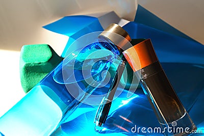 Creative layout made of dumbbell, men`s parfume, pen and water bottle for sport on folded paper of blue color. Minimal style Stock Photo