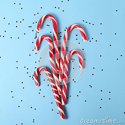 Creative layout made of lollipop cane and sparkling stars. Christmas holiday background, minimal s concept. Stock Photo