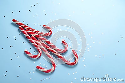 Creative layout made of lollipop cane and sparkling stars. Christmas holiday background, minimal s concept. Stock Photo