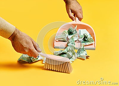 Creative layout with male hand sweeping money dollar bills on yellow background Stock Photo