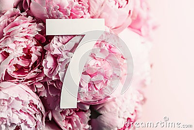 Creative layout. Pink peony flowers and digit seven 7. Birthday greeting card. Anniversary concept. Top view. Copy space. Stylish Stock Photo