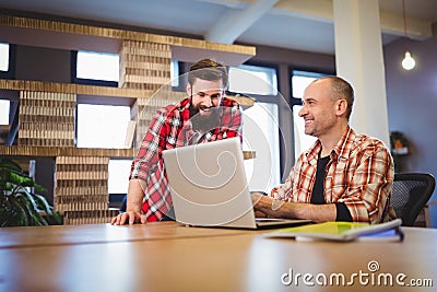 Creative male coworkers discussing over laptop Stock Photo
