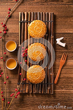 Creative Moon cake Mooncake table design - Chinese traditional pastry with tea cups on wooden background, Mid-Autumn Festival Stock Photo