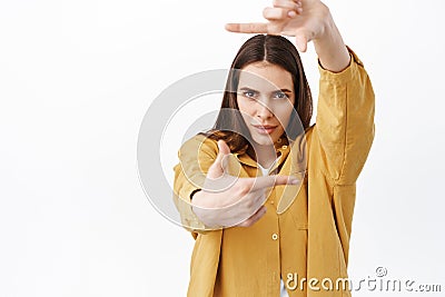 Creative and passionate woman searching perfect angle, looking through hand frames camera gesture and determined pensive Stock Photo