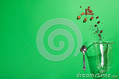 Cappuccino glass cup with sugar and coffee beans on green background with deep shadows, flat lay Stock Photo