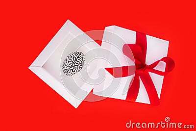Creative present to a genius in form of a small steel copy of a human brain inside a white gift box with a red ribbon and bow on Stock Photo