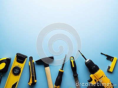 Creative provocation: a flat layout of yellow hand tools on a blue background. Stock Photo