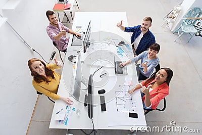 Creative team with computers showing thumbs up Stock Photo