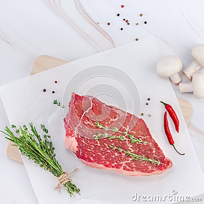 Creative Top view flat lay fresh raw beef meat striploin steak rosemary thyme herbs garlic pepper mushrooms meat white marble Stock Photo