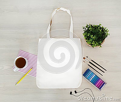 Creative, trendy, artistic eco, tote, cotton bag mock up. Mockup with earphones, a pencil,cup,paints,crayons, tassels. Stock Photo