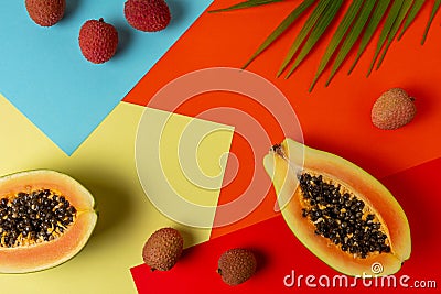 Creative tropical layout with papaya and litchi on colorful vivid paper. Minimal abstract summer concept. Flat lay Stock Photo