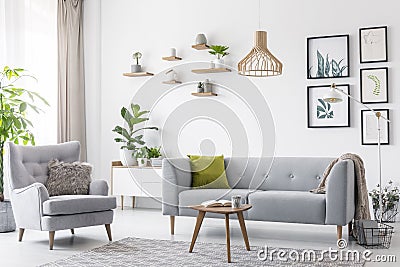Creative, wooden pendant light above a gray sofa and a comfy arm Stock Photo