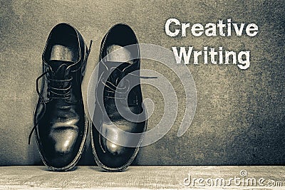 Creative Writing on brown board and work shoes on wooden floor Stock Photo