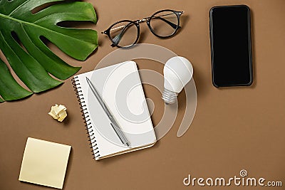 Creativity for success. Ideas inspiration concepts with lightbulb, modern smartphone, pen, monstera leaves, eyeglasses, notebook Stock Photo