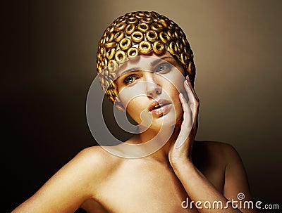 Creativity. Surreal Portrait of Stylized Woman with Golden Headwear as a Helmet Stock Photo