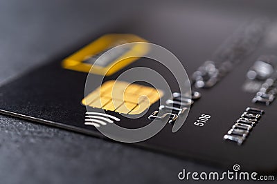 Credit card with chip and contactless technology macro. Black debit card for cash withdrawals and money transfers. Payment for Editorial Stock Photo