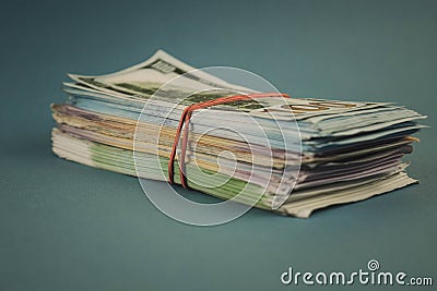 A bundle of money tied with a rubber band on a blue background Stock Photo