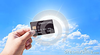 Credit cards and financial privileges concept, hand holding luxury credit card with sunlight and blue sky background Stock Photo