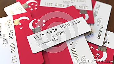 Pile of credit cards with flag of Singapore. Singaporean banking system conceptual 3D rendering Stock Photo