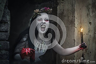 Creepy dead bride with candle screaming. Halloween scene Stock Photo