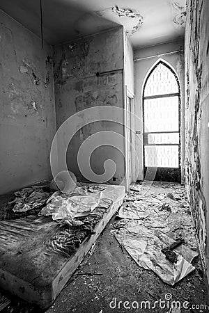 Creepy derelict bedroom with rusty mattress on the floor in an abandoned house Stock Photo