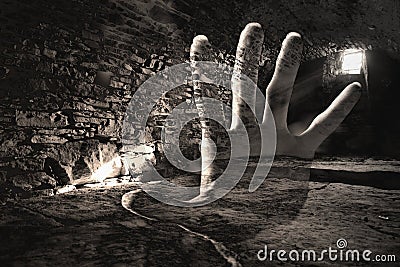 Creepy hand in the dark cell, scarry underground Stock Photo