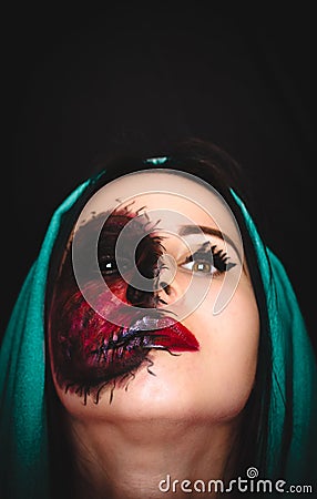 Creepy portrait of a woman with a cursed mark on her face on dark background with copy space Stock Photo