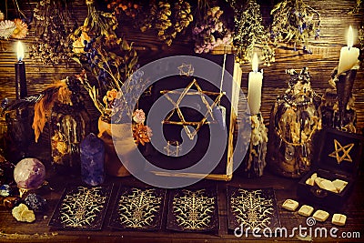 Creepy witch book with pentagram, tarot cards, runes, gemstone, candle and magic objects Stock Photo