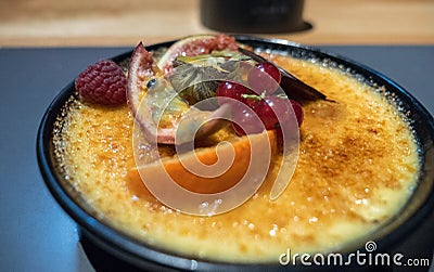Creme brulee with fruits on restaurant table Stock Photo
