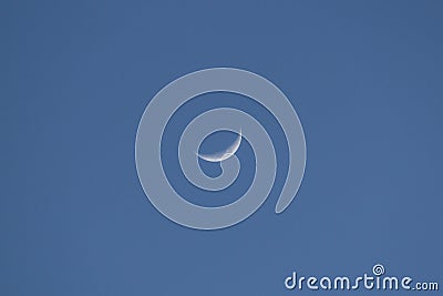 A crescent moon in the center of blue sky Stock Photo