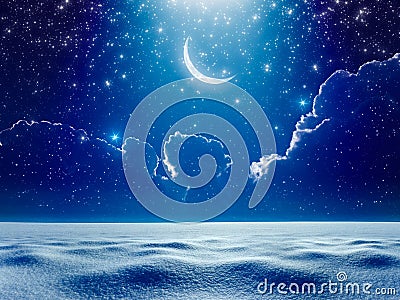 Crescent moon in dark blue night starry sky above snowy field, b Stock Photo