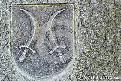 Crest with daggers on the stone wall Stock Photo