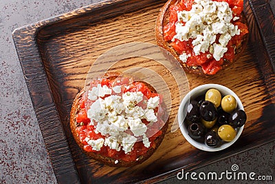 Cretan dakos is for a traditional salad from the island of Crete consists of barley rusk topped with juicy tomatoes, cheese and Stock Photo