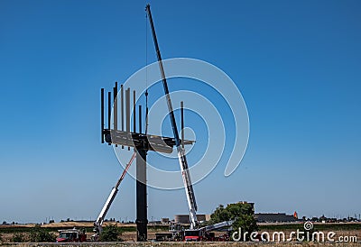 A crew erecting a business sign Editorial Stock Photo