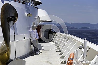 Crew members working onboard of a notorious Cruise ship company relaxing on the open decks while the vessel is docking the Editorial Stock Photo