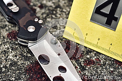 Crime scene investigation, Bloody knife and victim`s shoes with criminal markers on ground, Homicide evidence. Stock Photo