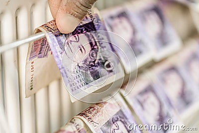 Criminal Hands In Gloves On British Sterling Pounds Notes On Clothes Dryer. Money Laundering Concept Editorial Stock Photo