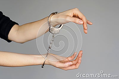 Criminal hands locked in handcuffs. Stock Photo