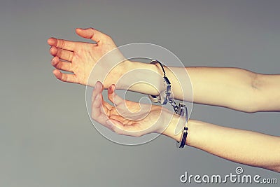 Criminal hands locked in handcuffs. Stock Photo