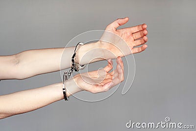 Criminal hands locked in handcuffs. Stock Photo