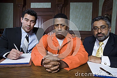 Criminal And Lawyers Sitting In Courtroom Stock Photo