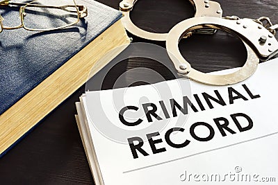 Criminal record and handcuffs on a desk. Stock Photo