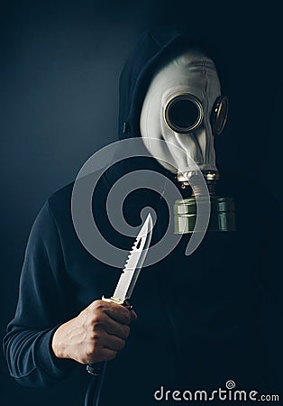 A scary thief in gas mask with a combat knife Stock Photo
