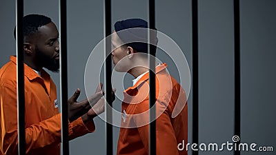 Criminals in prison cell conflicting, problem of jail overcrowding, aggression Stock Photo